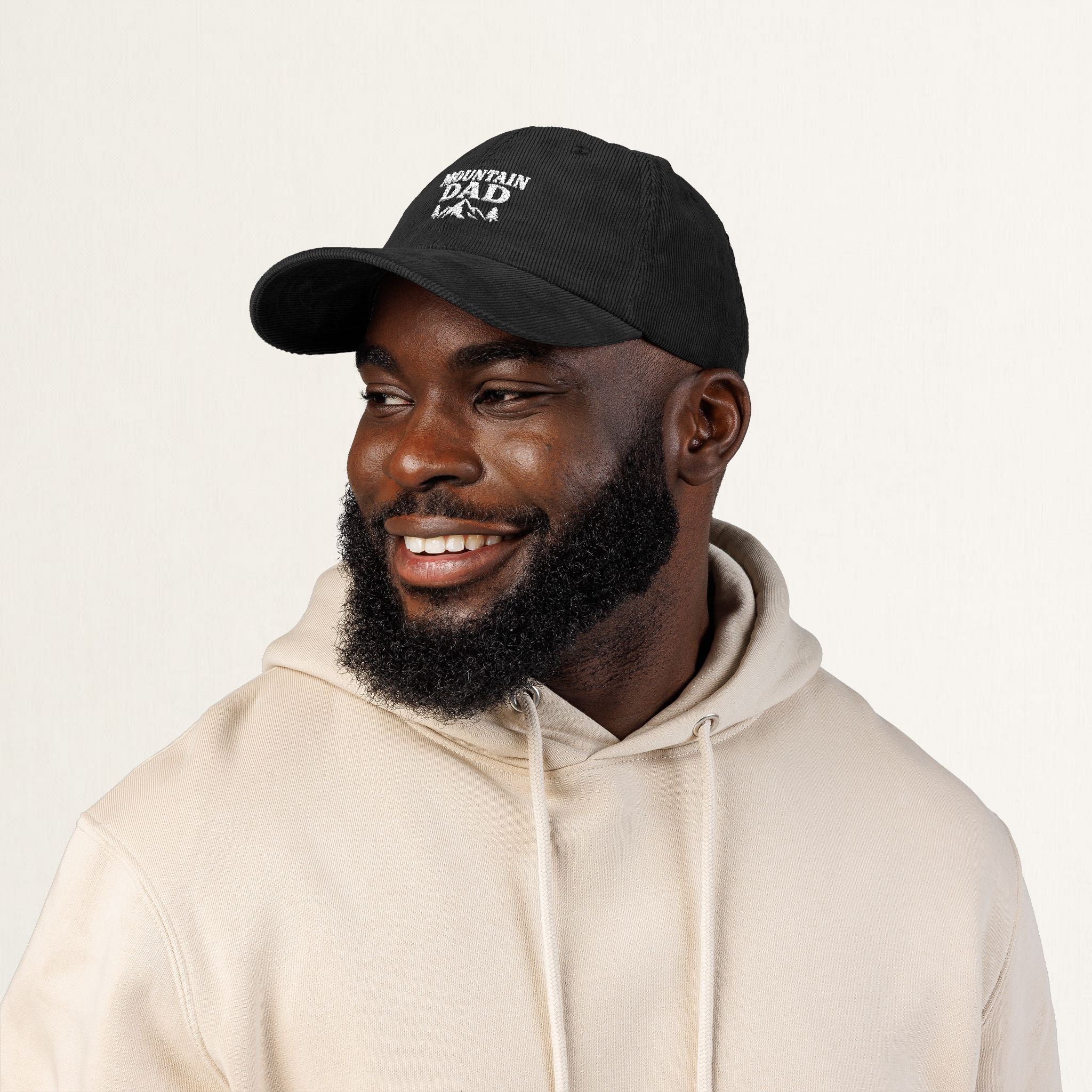 Angled view of a black corduroy Mountain Dad embroidered cap