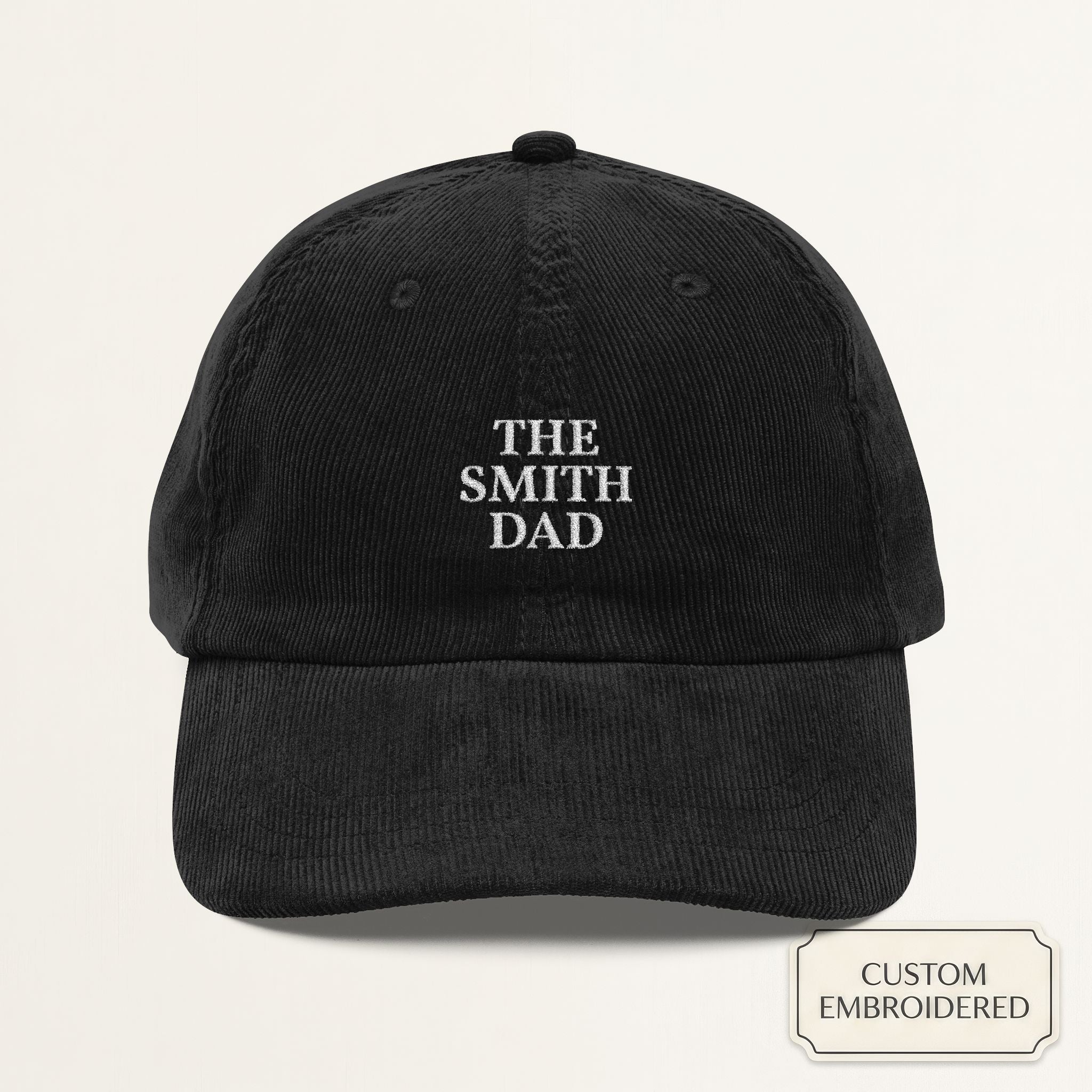 Personalized black corduroy dad cap embroidered with THE LAST NAME DAD — front view