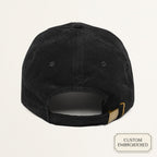 Back view of a black corduroy customizable cap showing the adjustable metal buckle closure