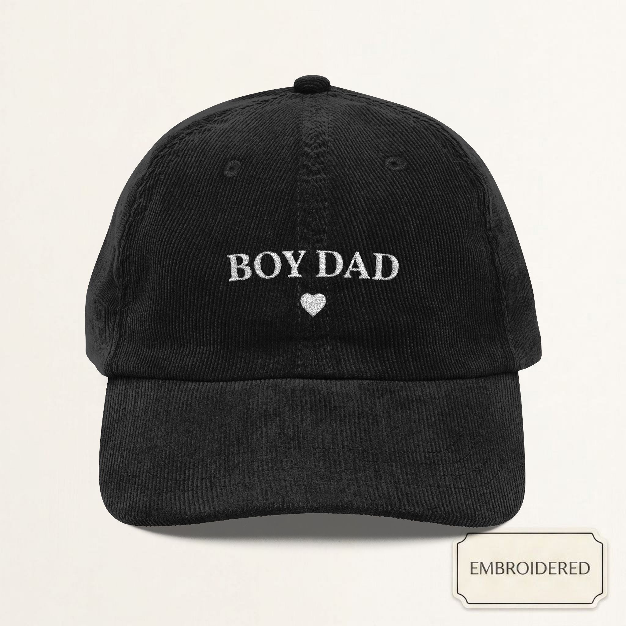 Black corduroy dad cap with small off-white embroidered BOY DAD text and heart on the front panel