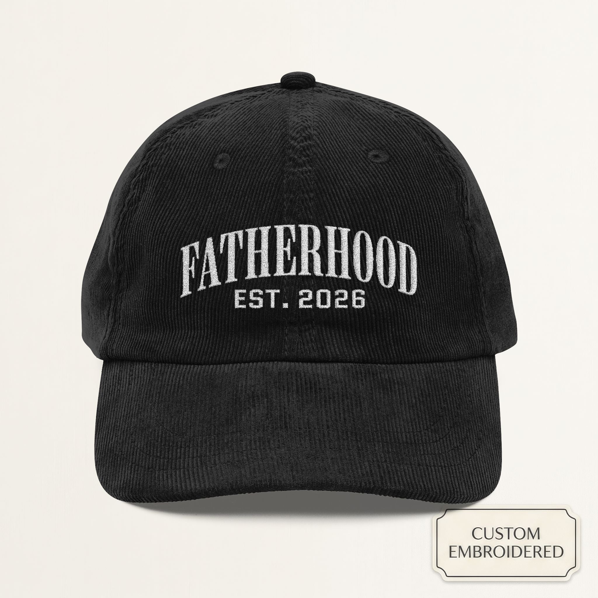 Personalized black corduroy dad cap embroidered with FATHERHOOD EST YEAR — front view