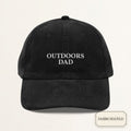 Black corduroy dad cap with small off-white embroidered OUTDOORS DAD text on the front panel