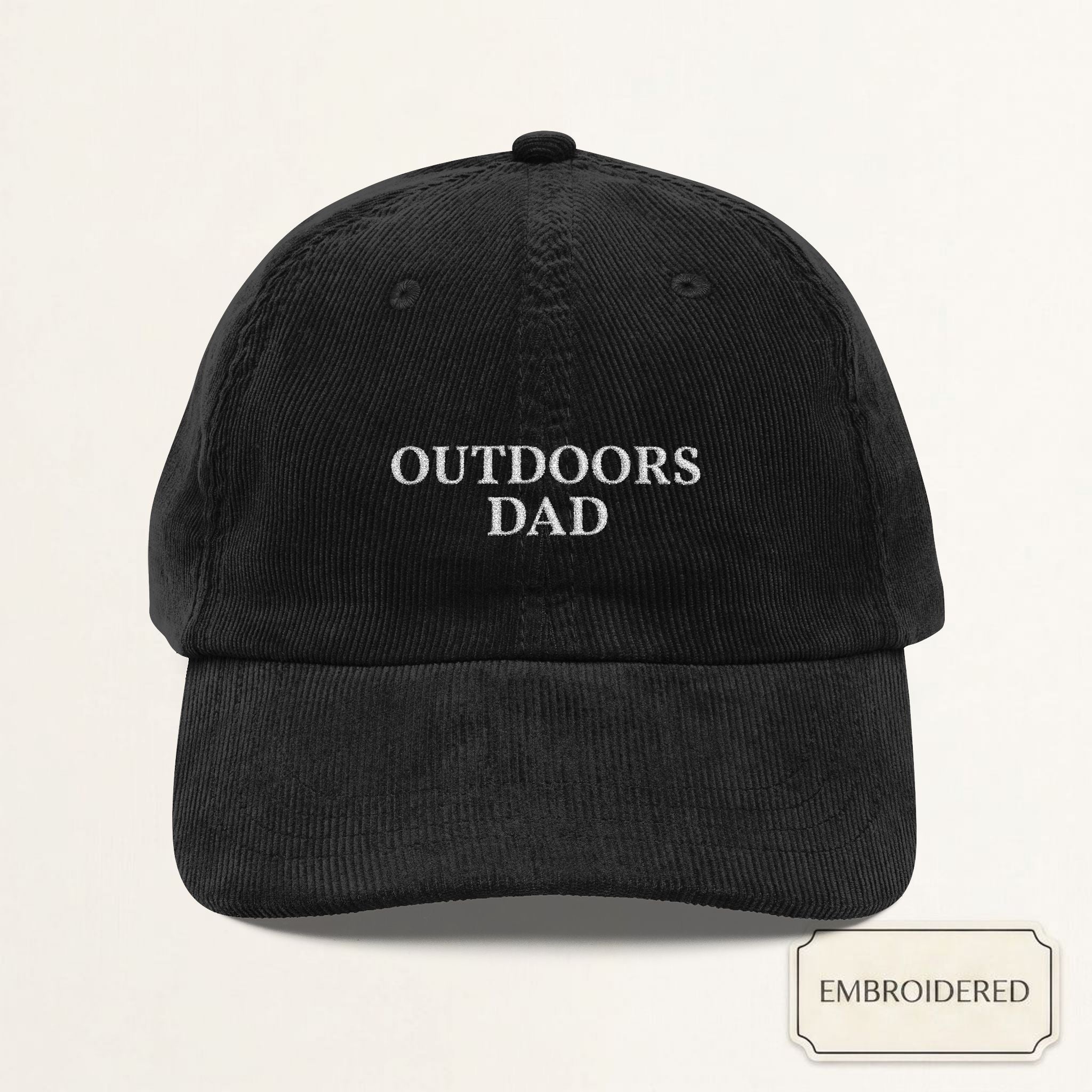 Black corduroy dad cap with small off-white embroidered OUTDOORS DAD text on the front panel